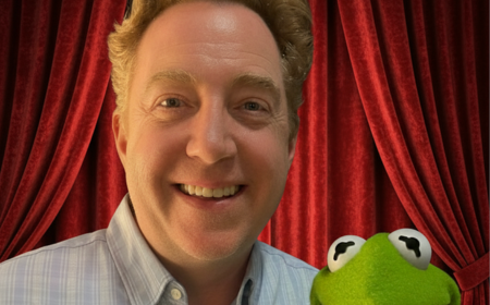 UCD alumnus Kelly Younger posing with Kermit the Frog.